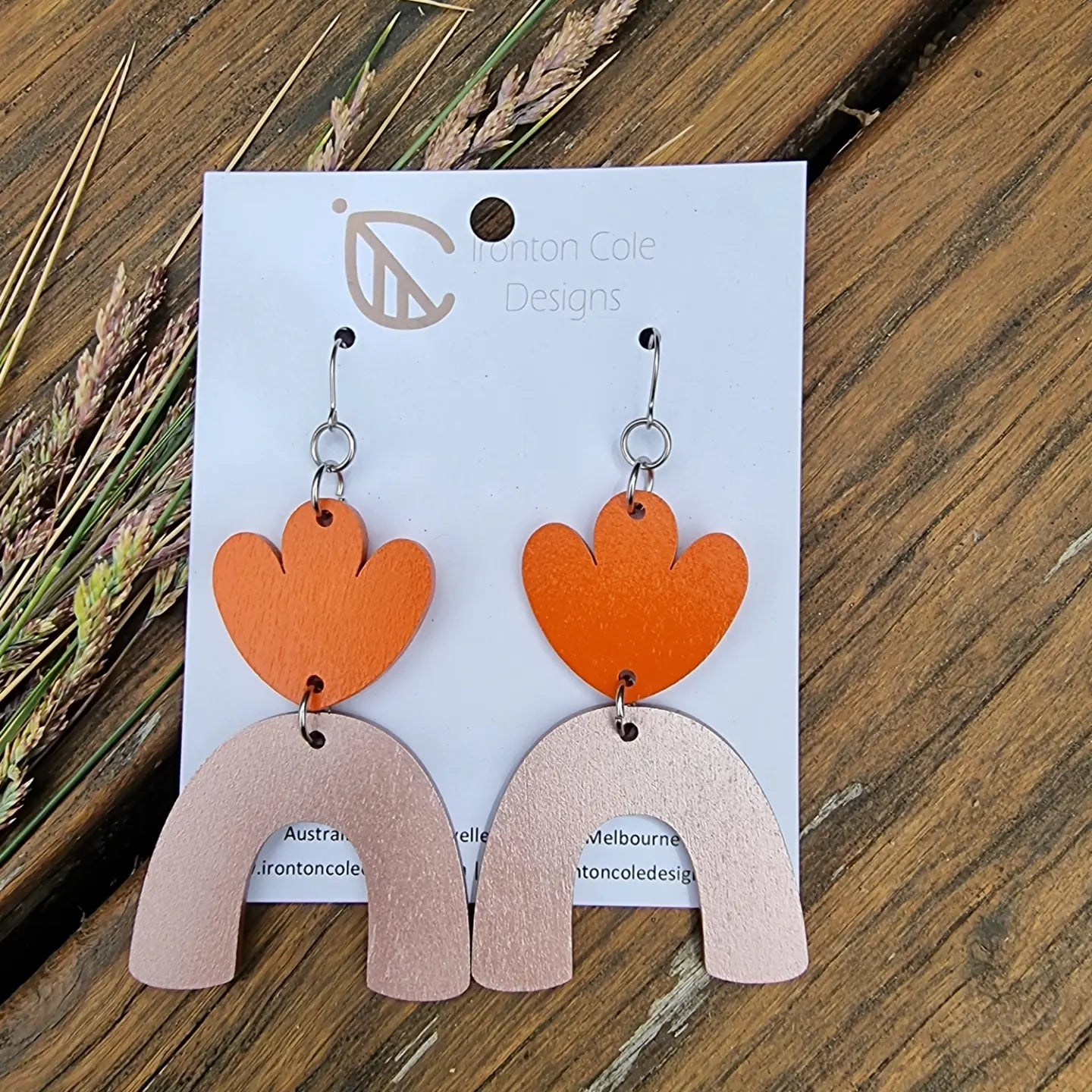 An orange painted flower petals paired with a bronze arch. Hypoallergenic silver hooks. 