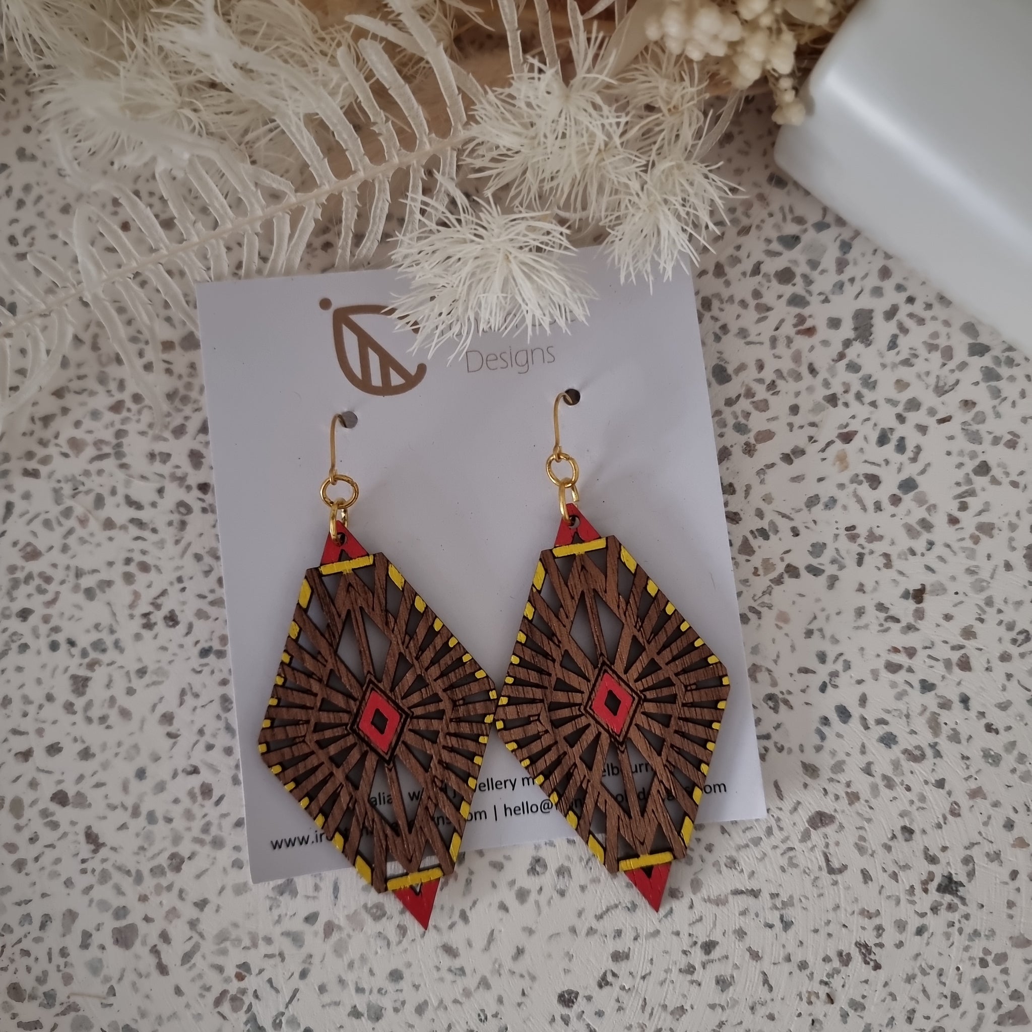 Wooden diamond shaped earrings with an art deco twist. Painted red and yellow with gold hooks.