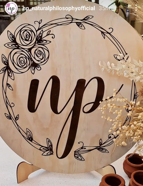 Round wooden sign with logo