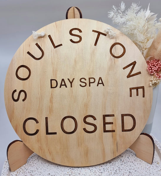 Round wooden sign with logo