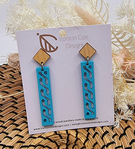 Baby blue painted wooden earrings in a shape of a bar with an s design.