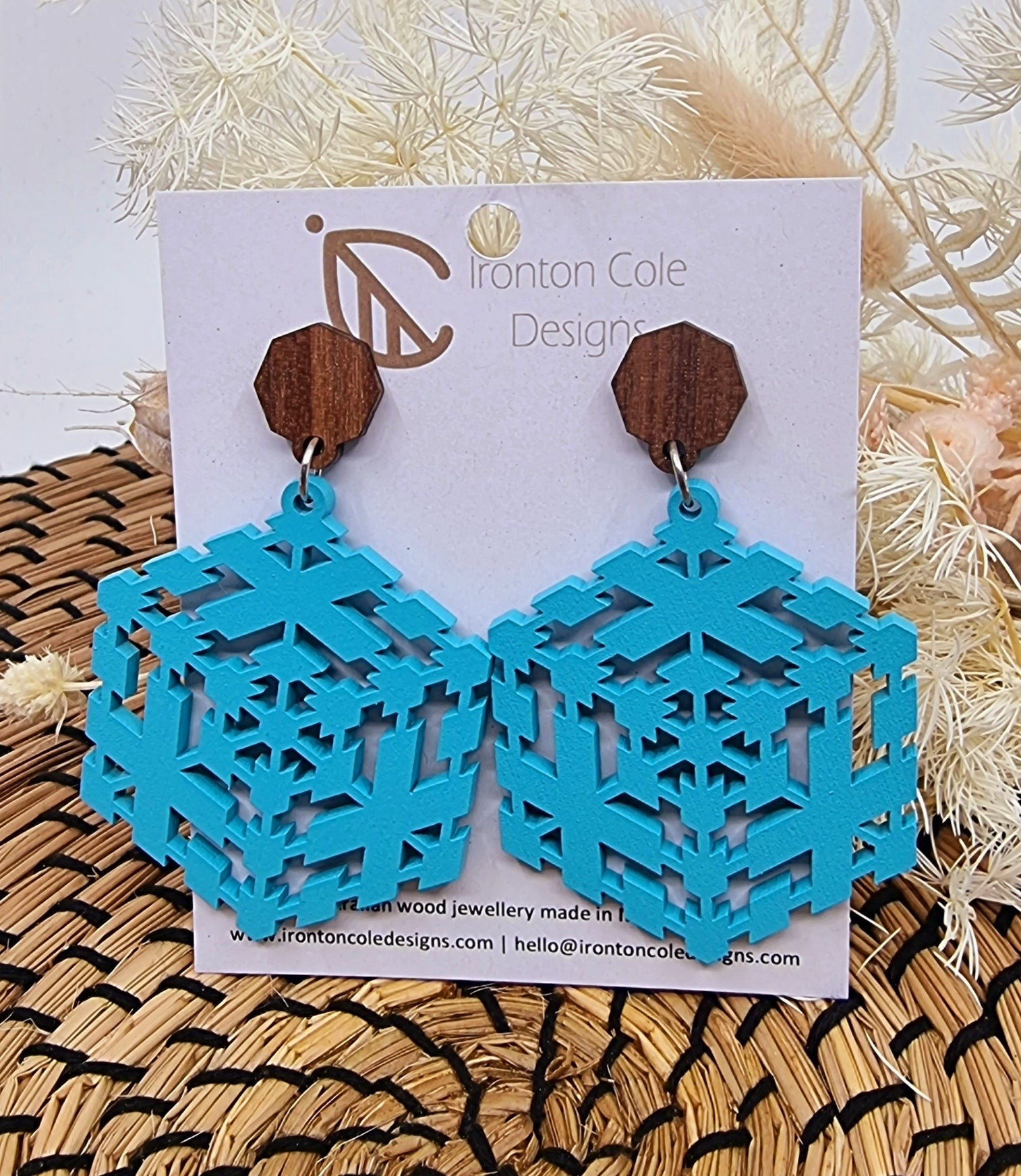 Wooden earrings in a 3d shape cut out with hexagon post.