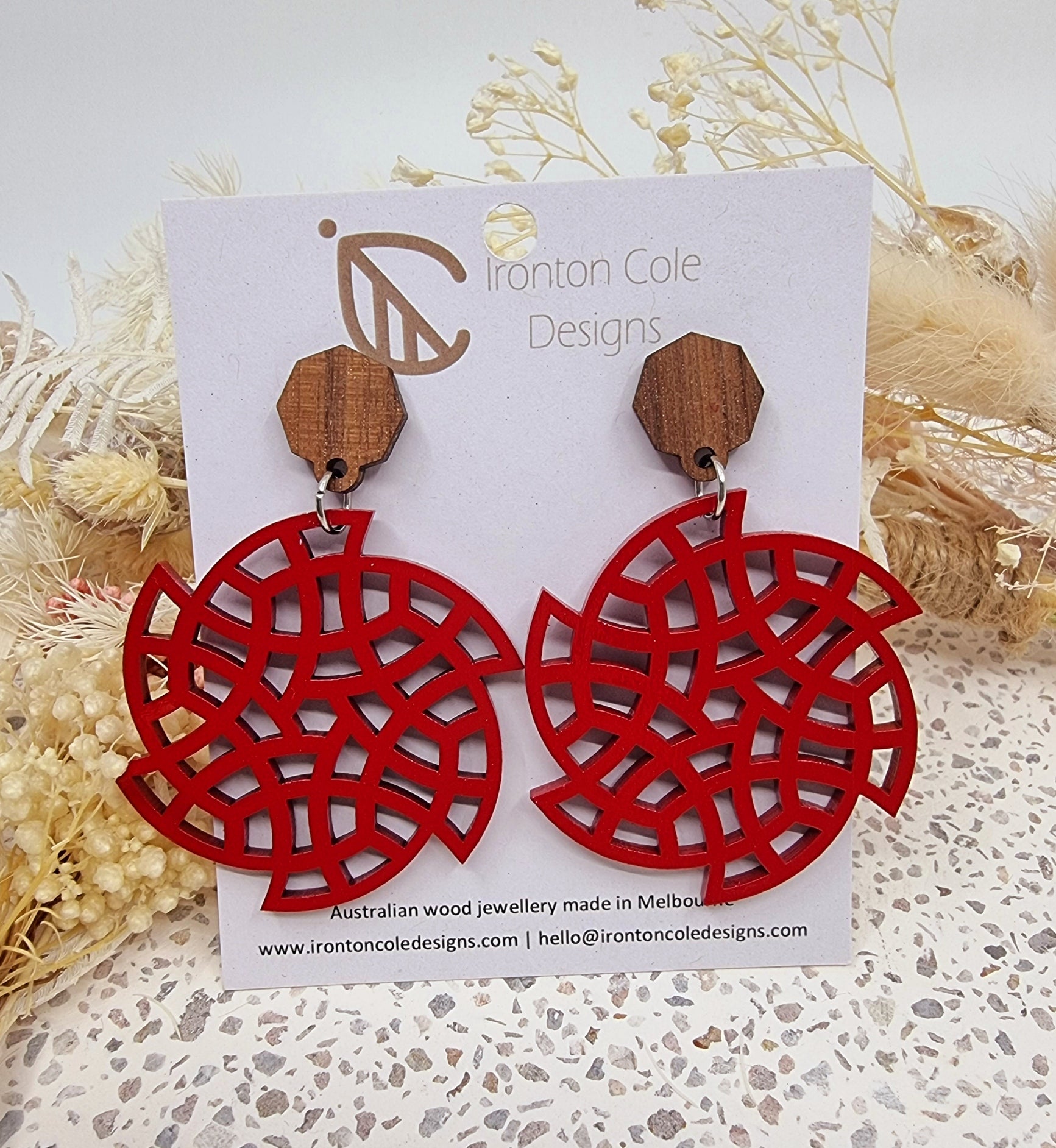 Fire red wooden earrings in a disc shape. 