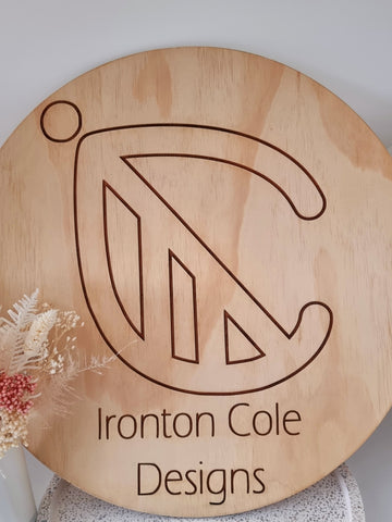 Round wooden sign with logo